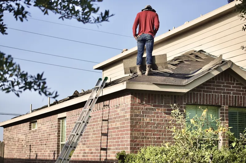 Professional roofer working on a residential roof in Straw-Smyth
